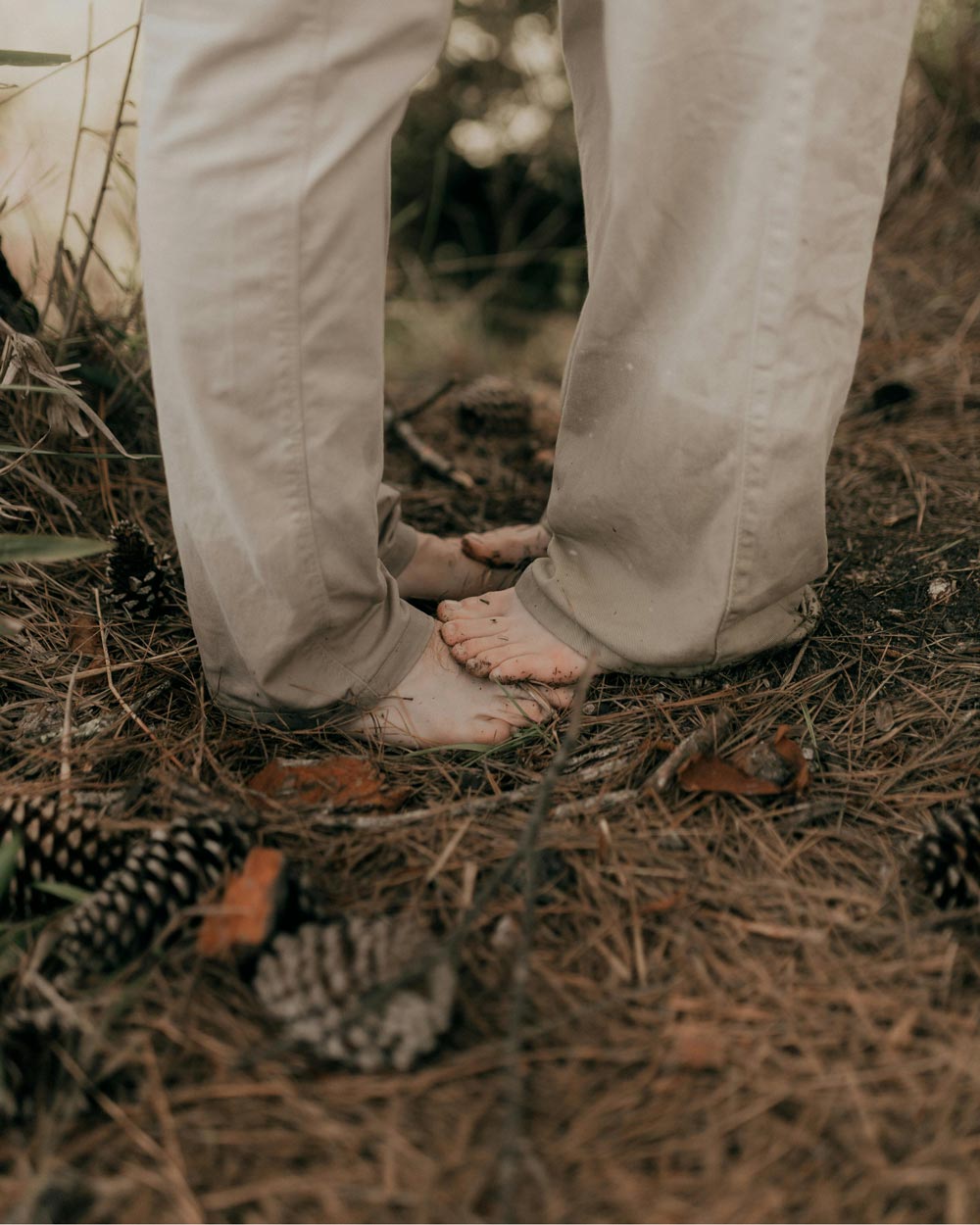 Couple standing on each others feet in a field